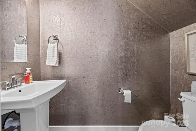 a bedroom with a large bed and a flat tv screen on dresser