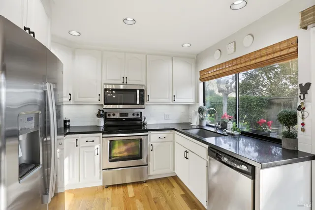 a kitchen with a sink cabinets and stainless steel appliances