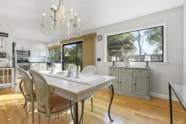 a view of a dining room with furniture a chandelier and wooden floor