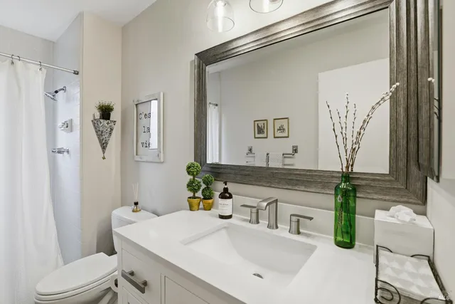 a bathroom with a sink a toilet and a mirror