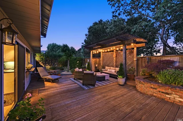 a view of a patio with table and chairs potted plants with wooden floor and fence