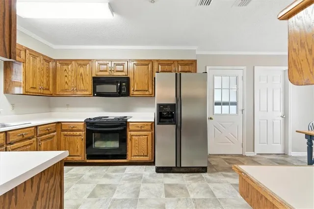 a dining area with stainless steel appliances a dining table chairs refrigerator and sink