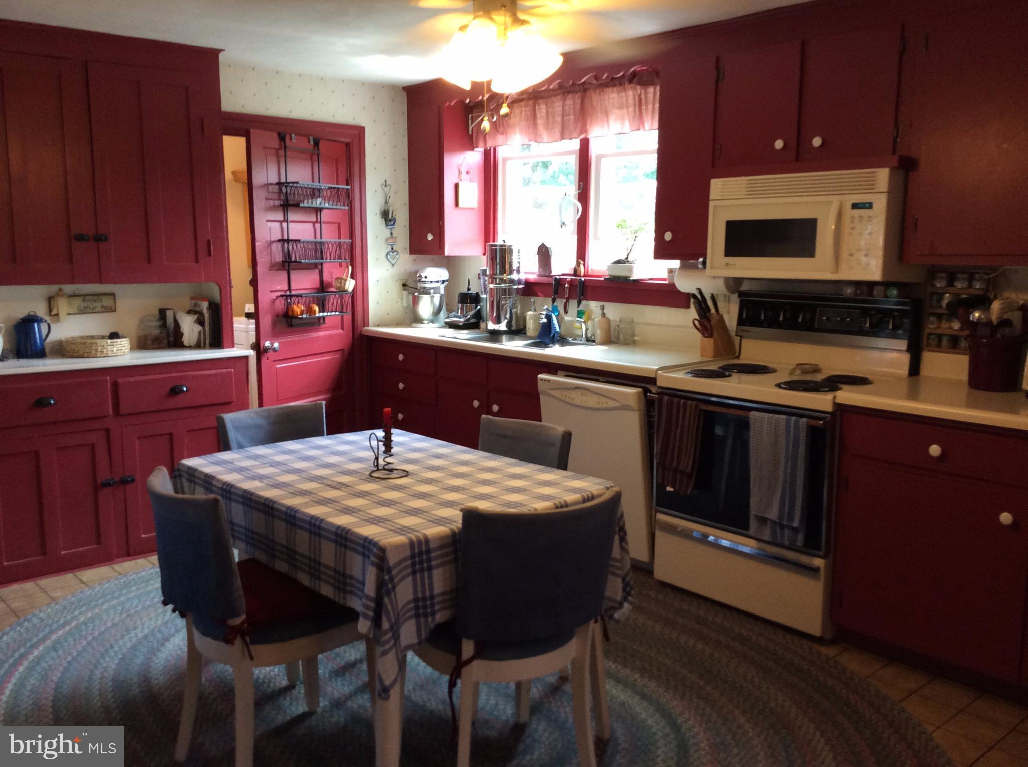 14736 Bottom Road Williamsport, MD 21795 - Photo 6 of 25 a kitchen with stainless steel appliances granite countertop a stove a sink dishwasher a microwave oven with a dining table and chair
