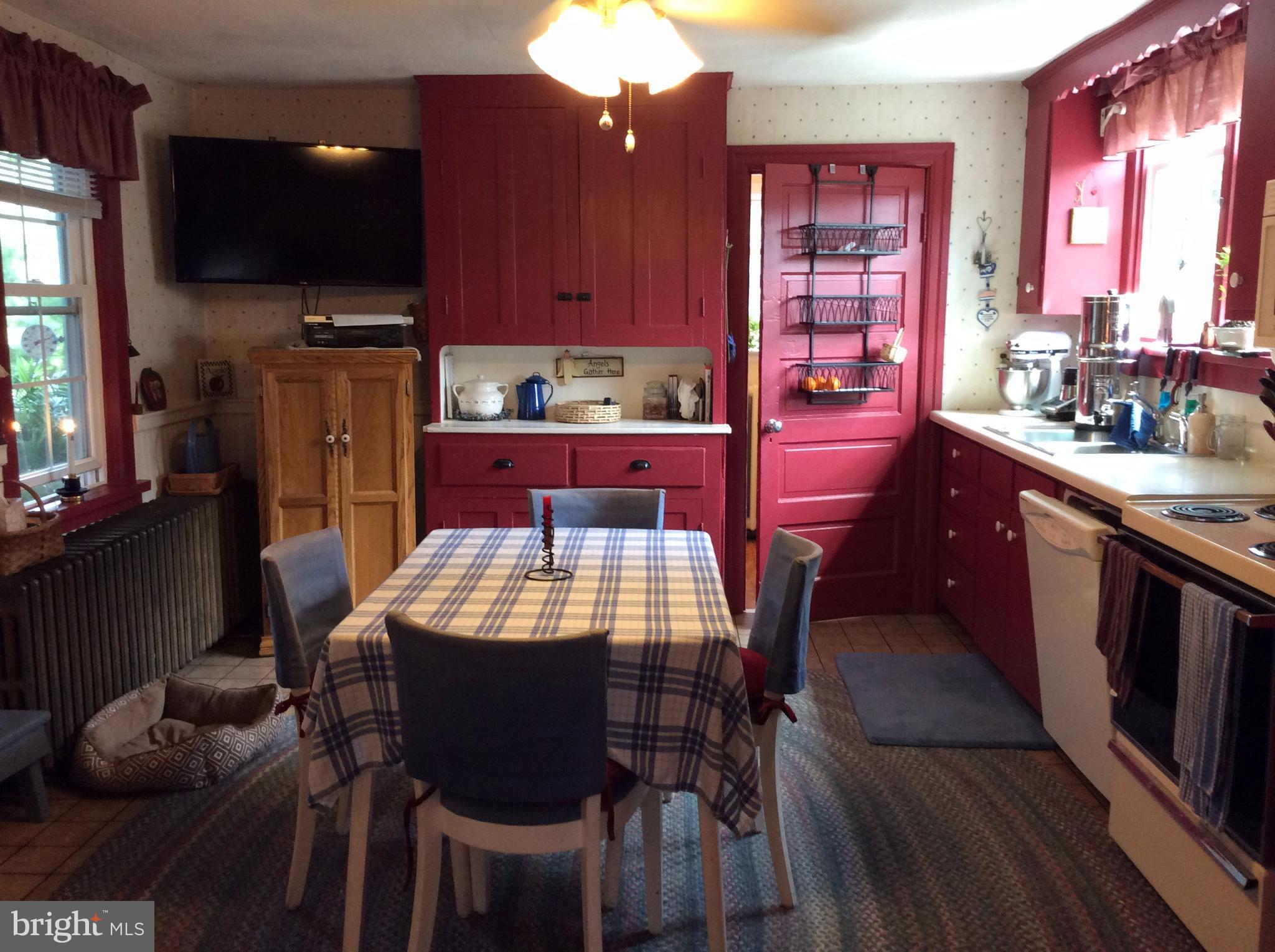 14736 Bottom Road Williamsport, MD 21795 - Photo 7 of 25 a kitchen with stainless steel appliances kitchen island granite countertop a table chairs in it and a flat screen tv