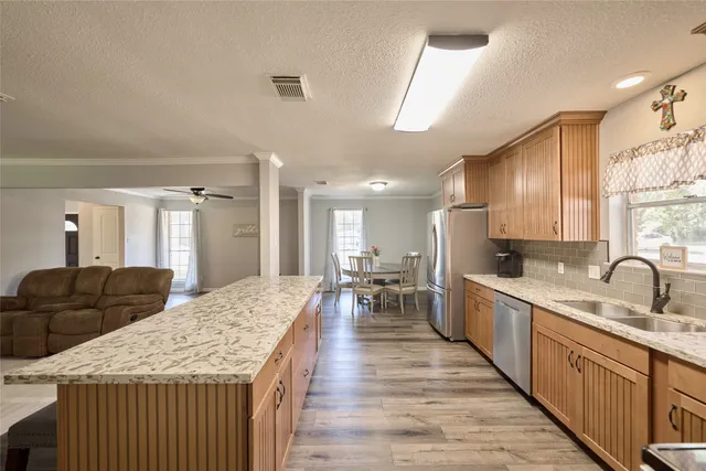 a kitchen with stainless steel appliances granite countertop a sink stove microwave and refrigerator