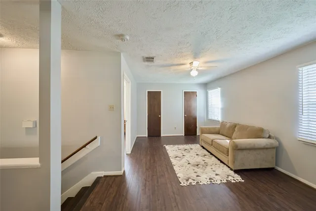 a living room with furniture and a wooden floor