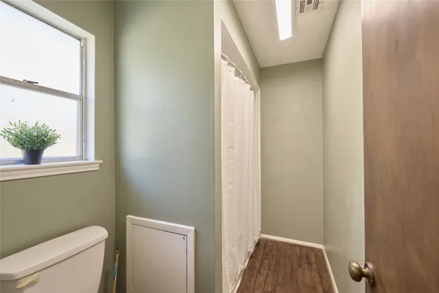 a bathroom with a toilet and a window