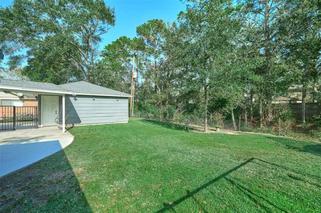 a view of a backyard with table and chairs and wooden fence