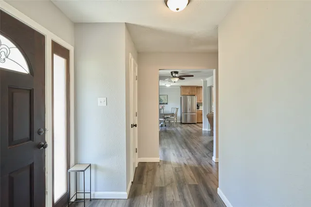 a view of a hallway with wooden floor and closet