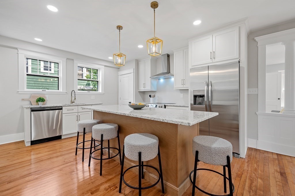 47 Brighton Road Worcester, MA 01606 - Photo 14 of 39 a kitchen with stainless steel appliances granite countertop a kitchen island a stove a table and chairs in it
