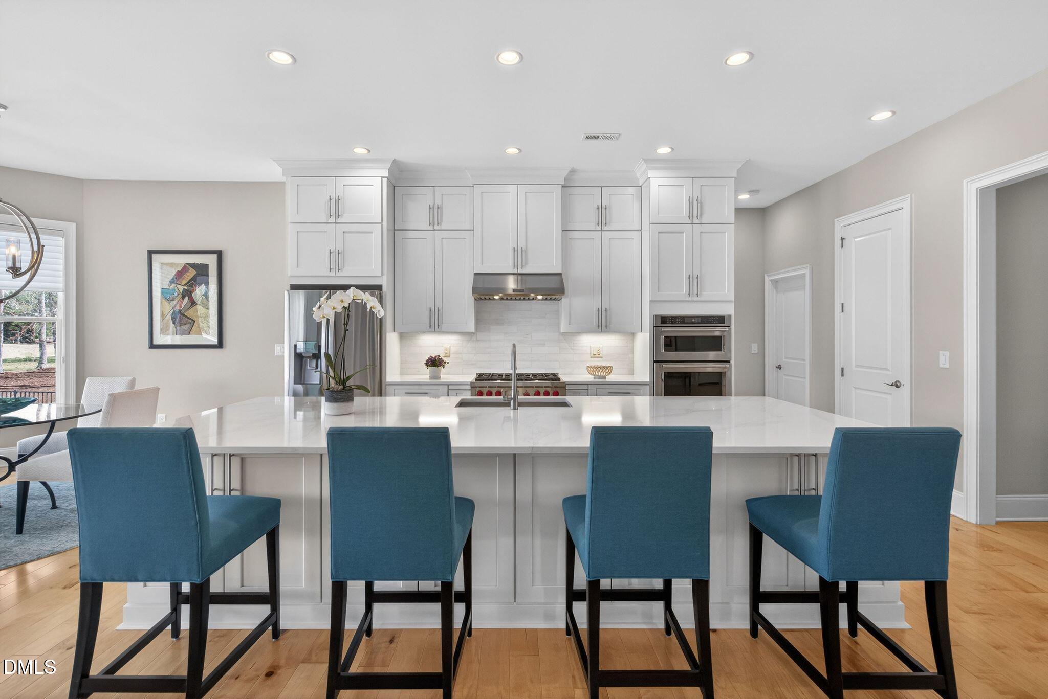 7440 Hasentree Way Wake Forest, NC 27587 - Photo 6 of 64 a kitchen with a dining table chairs and refrigerator