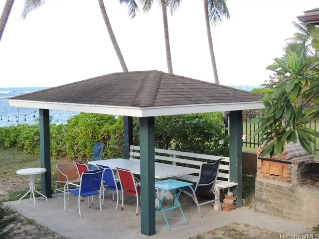 a view of wooden chairs and table under an umbrella