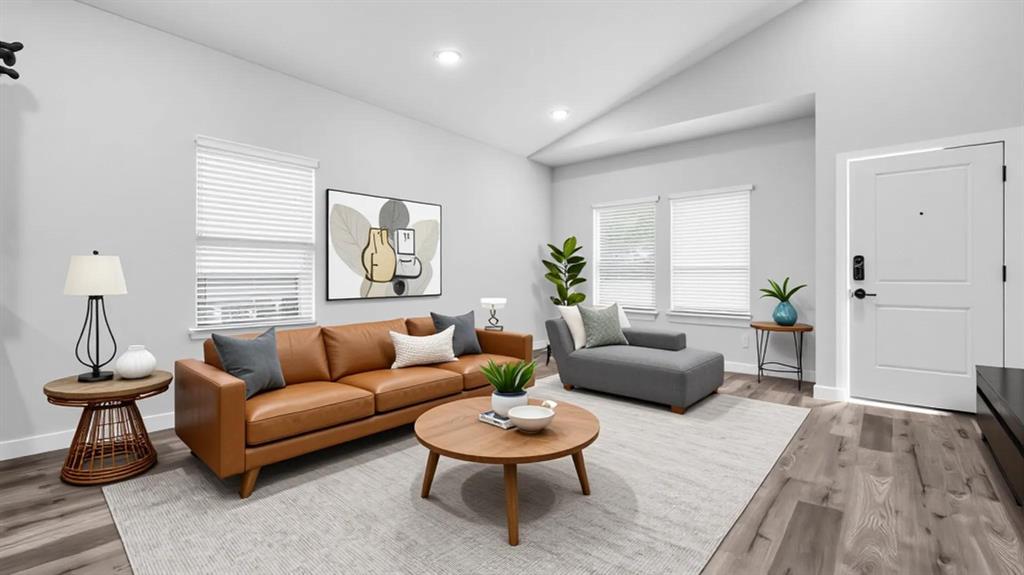 716 East Chestnut Street Denison, TX 75021 - Photo 5 of 26 Light-filled living area featuring wood-finish flooring, a white paneled entry door with smart lock, multiple windows with blinds, recessed lighting, and a vaulted ceiling