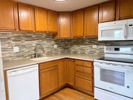 a kitchen with granite countertop wooden cabinets stainless steel appliances and a sink