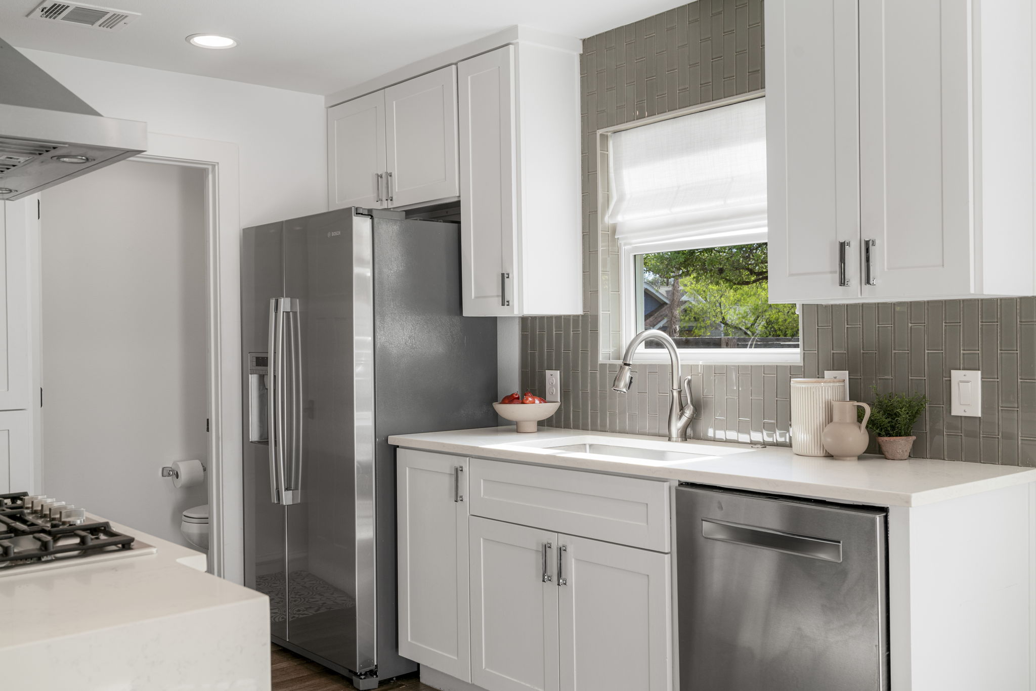 605 Harris Avenue Austin, TX 78705 - Photo 13 of 34 The gorgeous tile backsplash adds just the right amount of warmth and texture against crisp white cabinetry and quartz countertops.