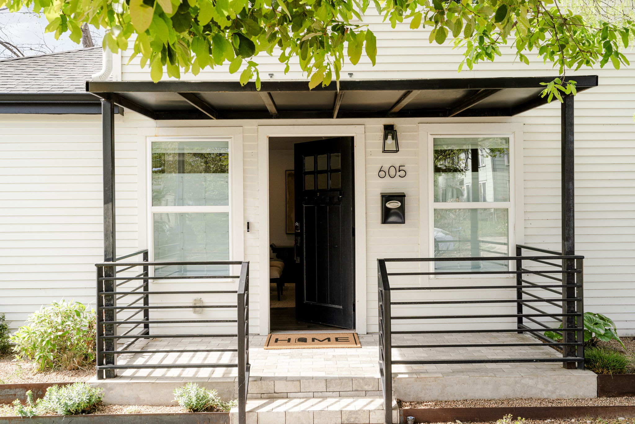 605 Harris Avenue Austin, TX 78705 - Photo 2 of 34 A modern black canopy, black front door, and clean steel railings give the entry a quiet confidence that carries all the way through the interior.