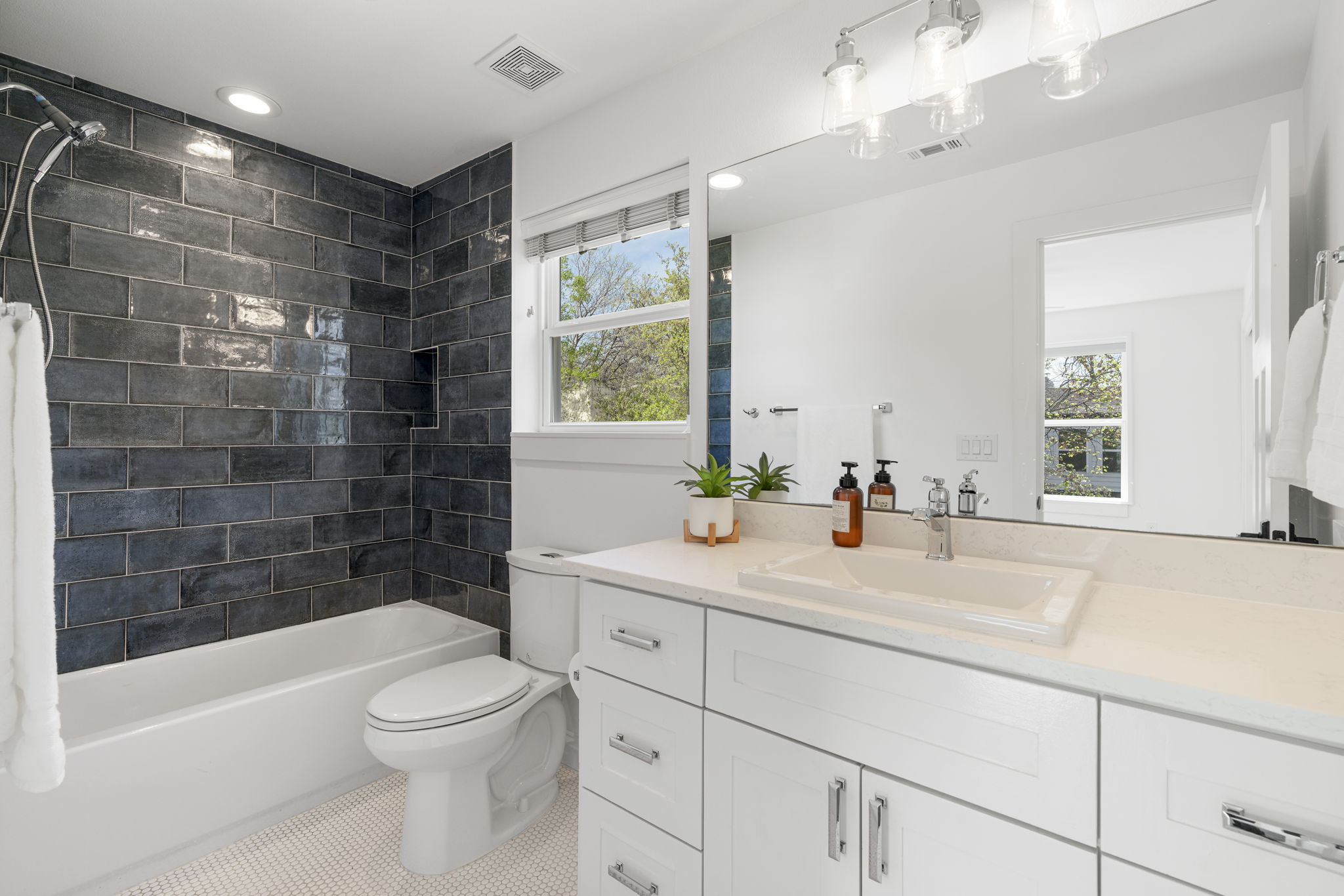 605 Harris Avenue Austin, TX 78705 - Photo 22 of 34 The hall bath strikes a perfect balance between bold and beautiful, with quartz countertops and penny tile floors completing the look.