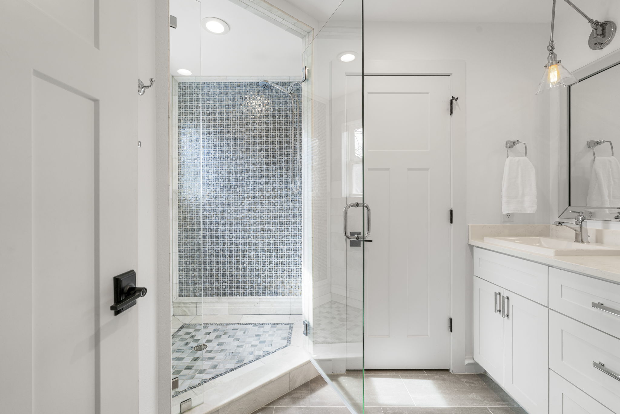 605 Harris Avenue Austin, TX 78705 - Photo 7 of 34 A glass-enclosed walk-in shower with floor-to-ceiling mosaic tile and a beautiful patterned mosaic floor makes getting ready feel like a little luxury.
