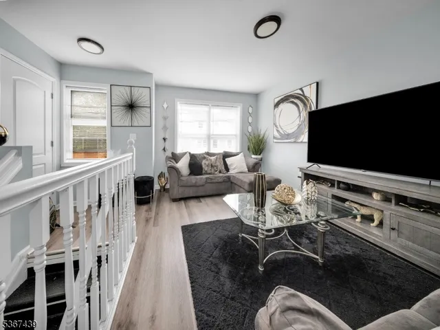 a living room with furniture flat screen tv and a large window