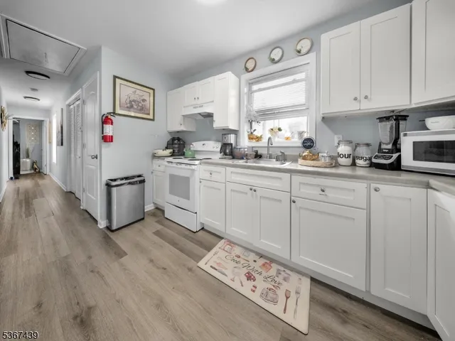 a kitchen with white cabinets and white appliances