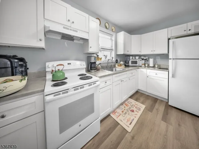 a kitchen with cabinets appliances a sink and a counter space