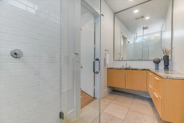 a bathroom with a tub a sink a mirror and a shower