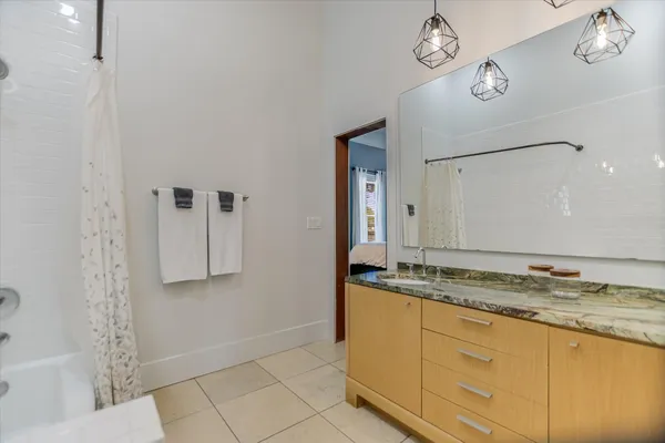 a bathroom with a granite countertop sink a mirror and shower