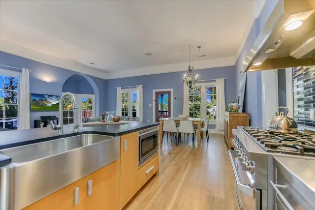 a view of a kitchen with kitchen island a large counter top space a sink stainless steel appliances and cabinets