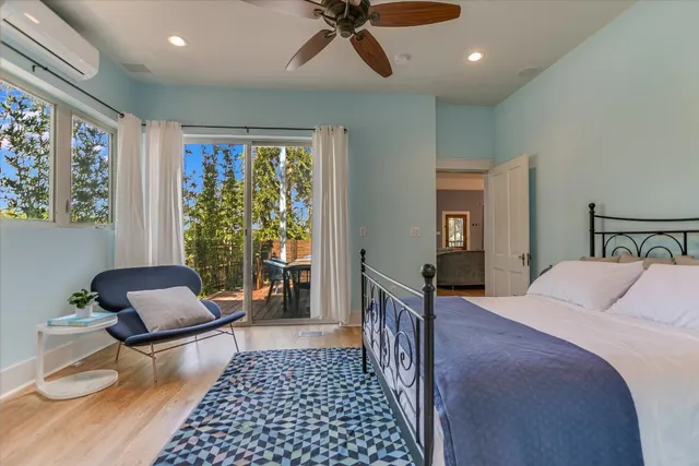 a bedroom with furniture and a large window