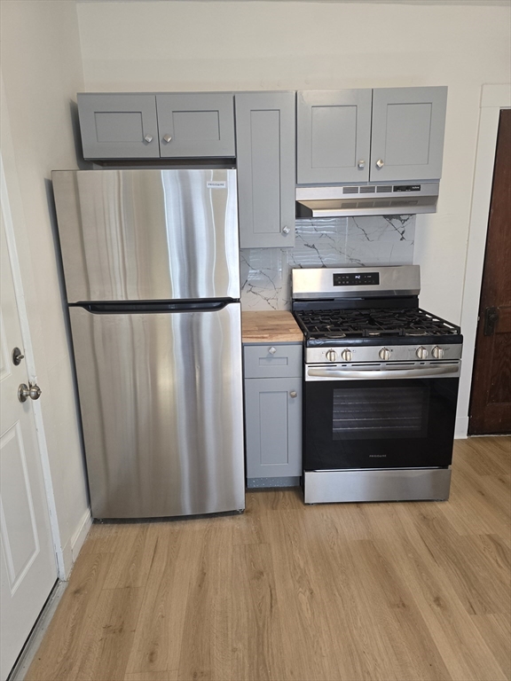 105 Fuller Street, Unit 1 Boston, MA 02124 - Photo 2 of 6 a kitchen with a stove and a refrigerator