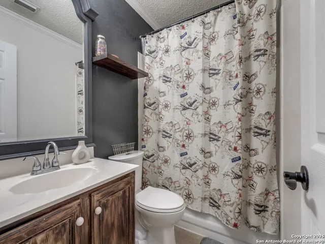 a bathroom with a granite countertop sink a toilet and a mirror