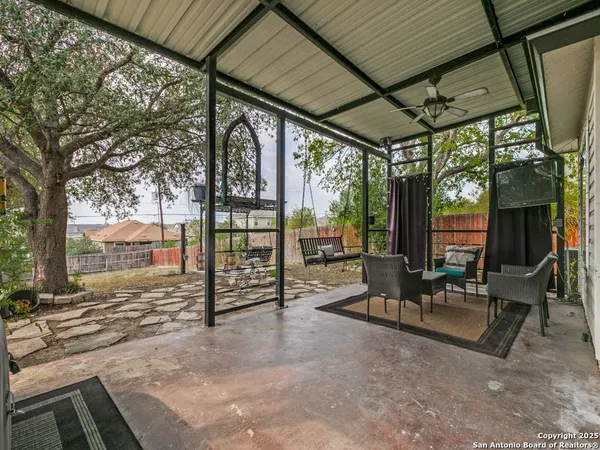 a view of a patio with table and chairs next to a yard