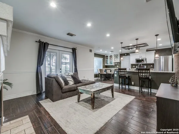 a living room with lots of furniture and kitchen view