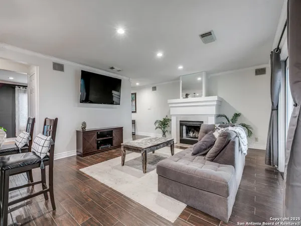 a living room with furniture a fireplace and a flat screen tv