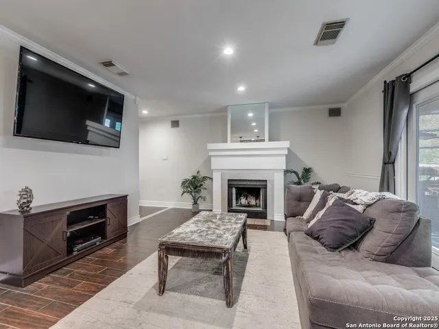 a living room with furniture a fireplace and a flat screen tv