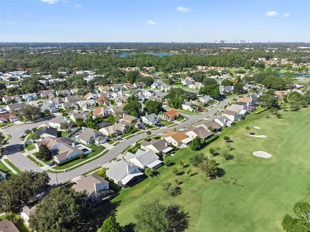 an aerial view of residential houses with outdoor space and trees