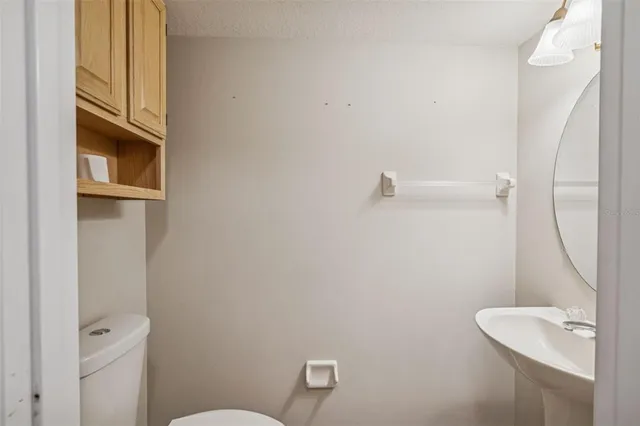 a bathroom with a toilet a sink and mirror