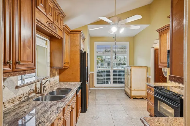 a kitchen with granite countertop a sink and a refrigerator