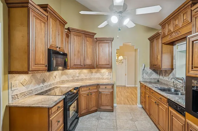 a large kitchen with kitchen island granite countertop a sink and stainless steel appliances
