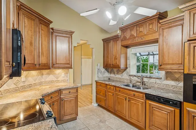 a large kitchen with kitchen island granite countertop a sink and cabinets