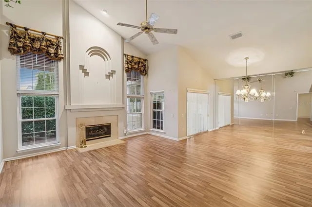 a view of empty room with wooden floor and fireplace