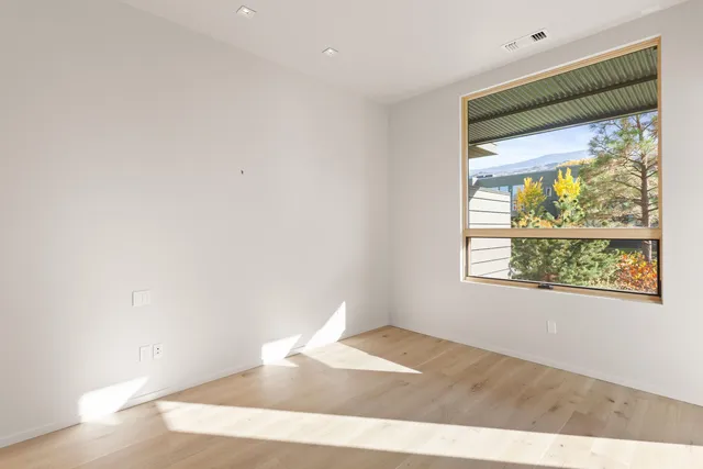 a view of a big room with wooden floor and windows