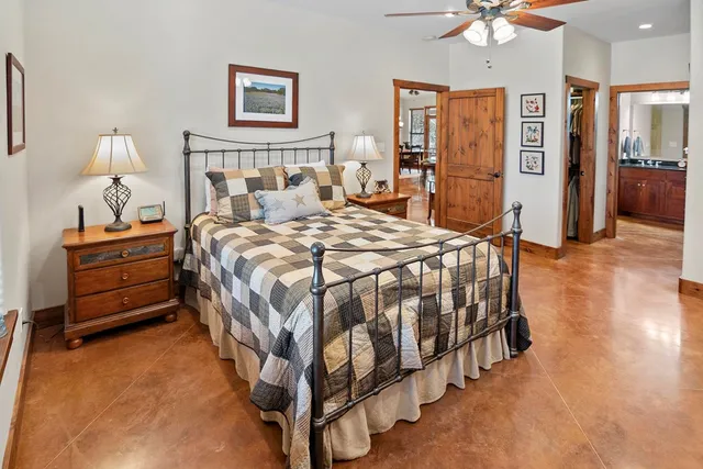 a bedroom with a bed a chair and a chandelier