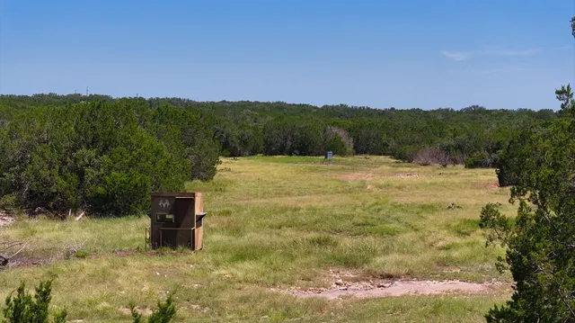 a backyard of a house with lots of green space and house in the back
