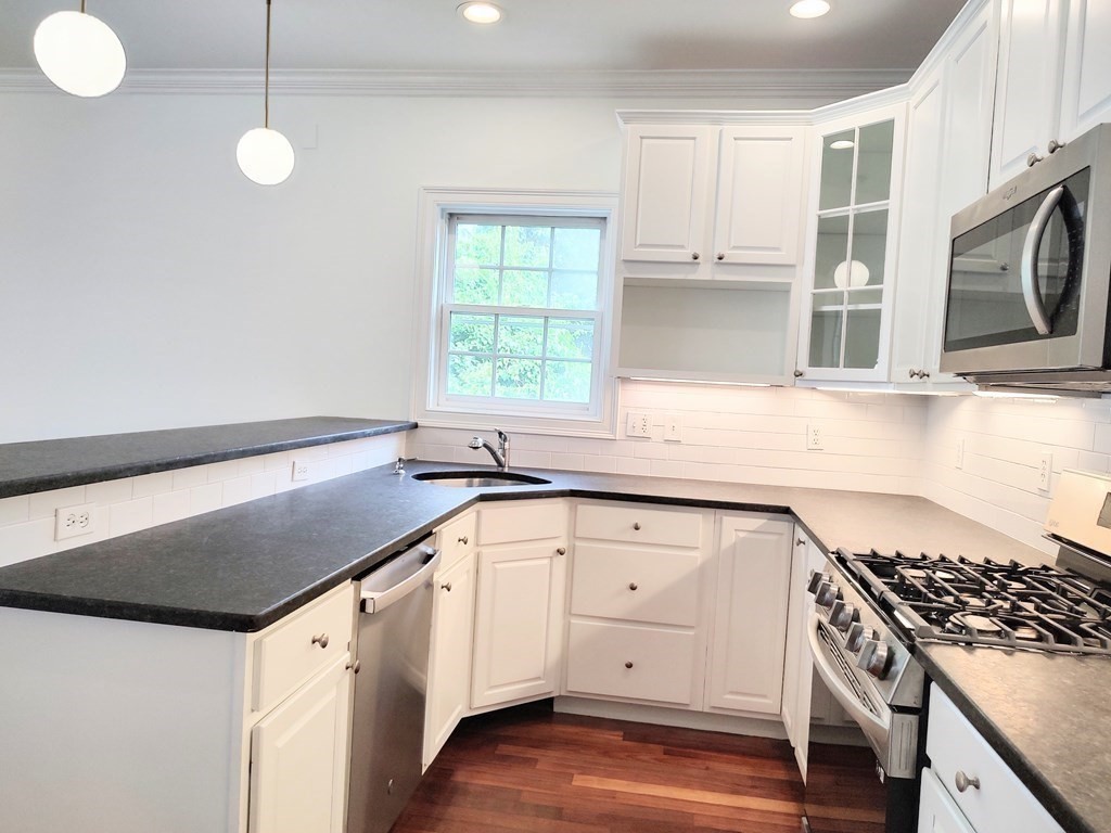 604 Freeport Street, Unit PH 5 Boston, MA 02122 - Photo 11 of 38 a kitchen with granite countertop a sink a stove and cabinets