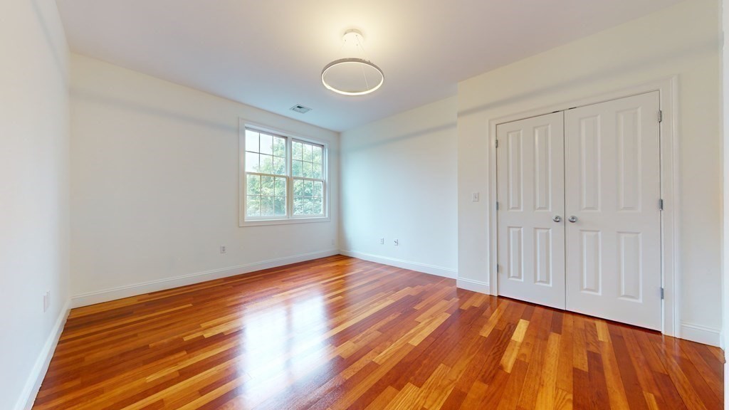 604 Freeport Street, Unit PH 5 Boston, MA 02122 - Photo 16 of 38 wooden floor in an empty room with a window