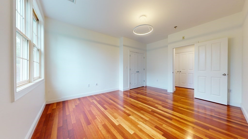 604 Freeport Street, Unit PH 5 Boston, MA 02122 - Photo 17 of 38 a view of empty room with wooden floor and fan