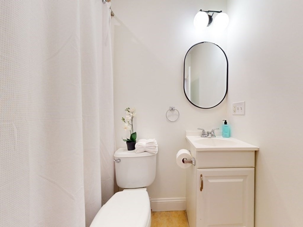 604 Freeport Street, Unit PH 5 Boston, MA 02122 - Photo 19 of 38 a bathroom with a toilet sink and mirror