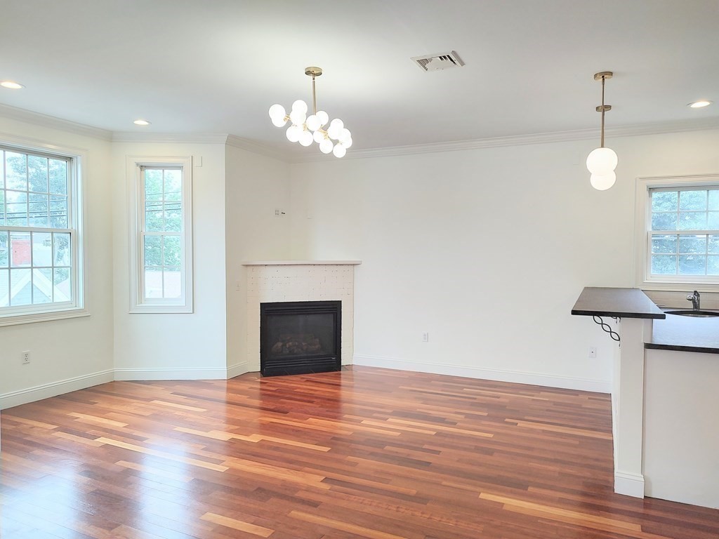 604 Freeport Street, Unit PH 5 Boston, MA 02122 - Photo 2 of 38 an empty room with wooden floor fan and windows