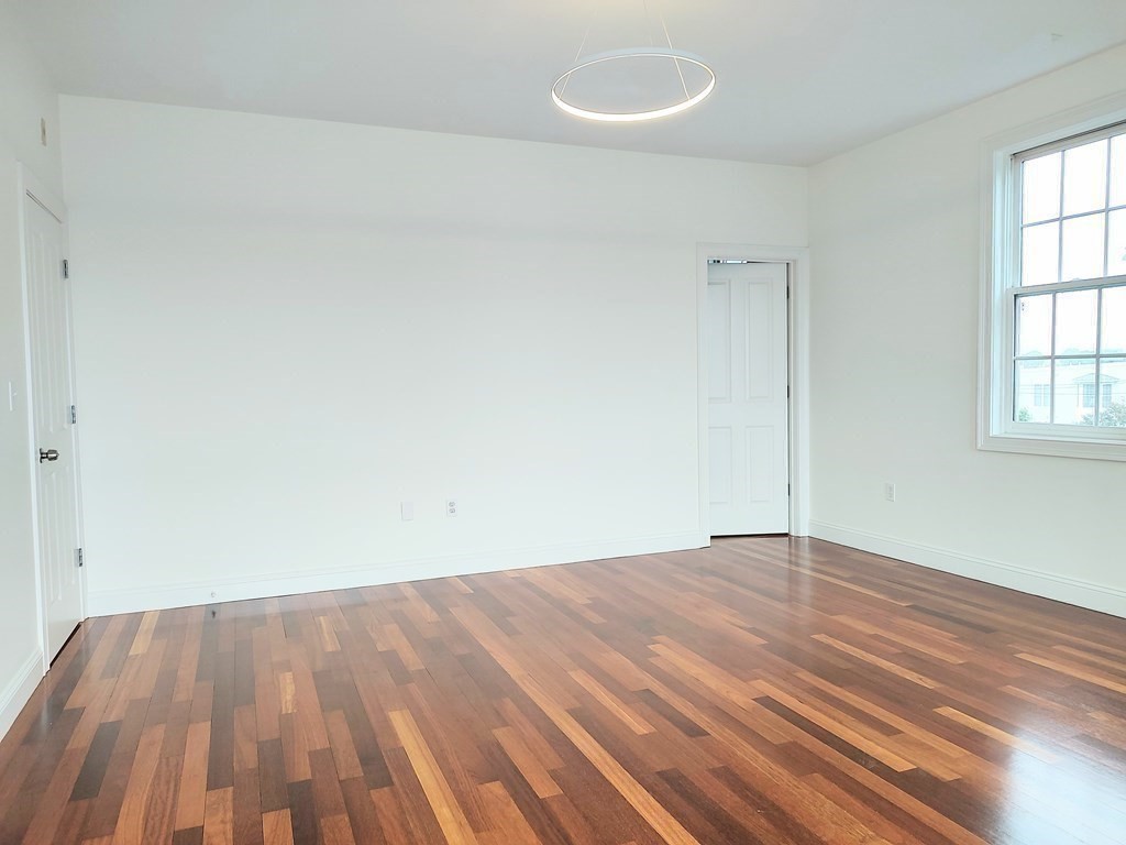 604 Freeport Street, Unit PH 5 Boston, MA 02122 - Photo 21 of 38 an empty room with wooden floor and windows